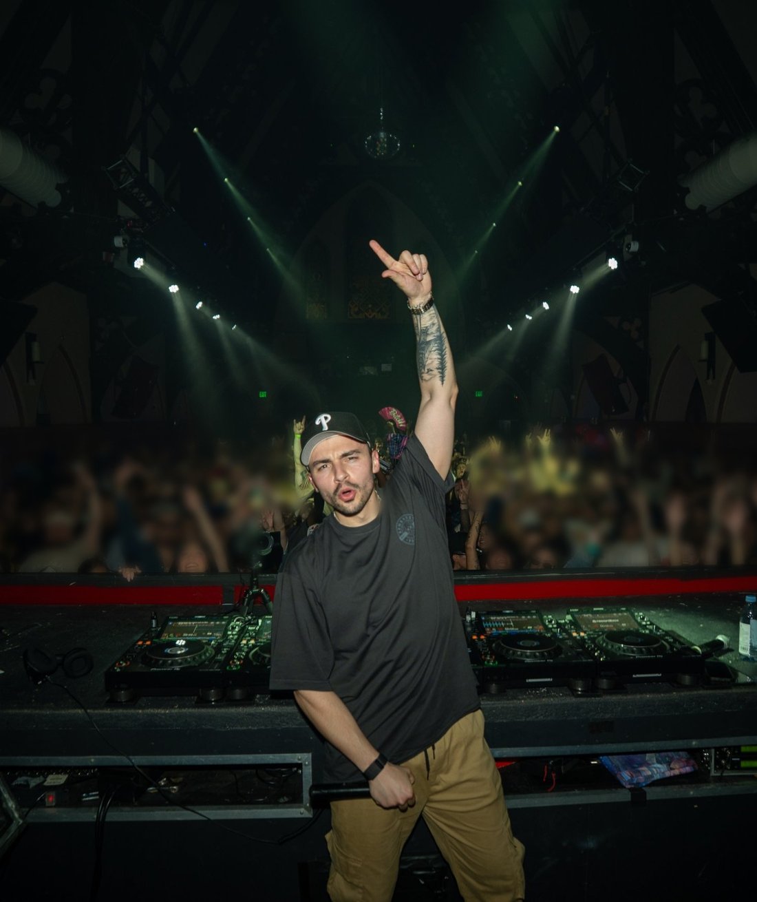 Michael Stryer behind the decks, arm raised to a packed crowd